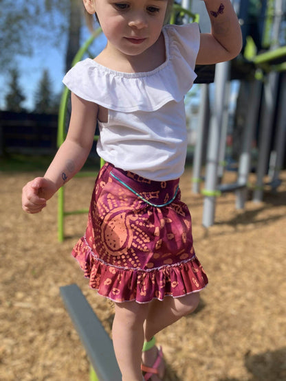 Fille portant une Mini-SANTANA - Jupe longue à volants pour filles du 2 au 16 Ans, patron de couture pdf à télécharger. Jupe bohème rose.