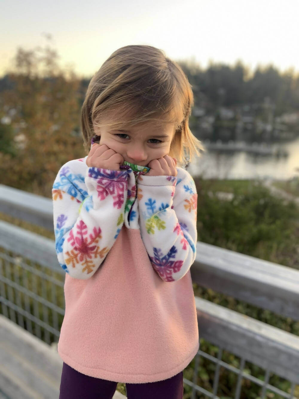 Enfant portant le Mini-SHERPA - Polaire mixte pour enfants du 2 au 16 Ans, patron de couture pdf à télécharger, avec motif flocons colorés.