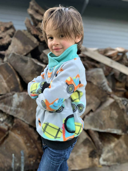 Enfant portant le Options Sweat TITUS du 2 au 16 Ans, patron de couture PDF à télécharger, avec motifs colorés et col roulé.