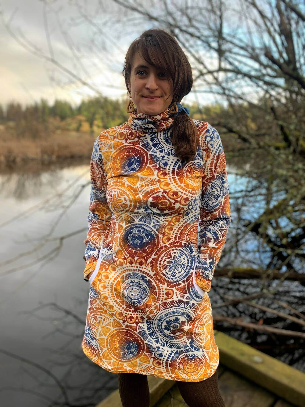 Femme portant la Robe Sweat MILA pour femmes du 34 au 54, patron de couture pdf à télécharger, avec un motif coloré en extérieur.