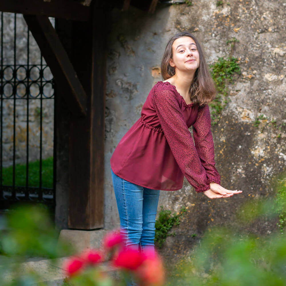 Jeune femme portant une blouse Mirabelle dans un jardin, patron de couture pdf à télécharger, tailles 34 au 56, 4 statures.