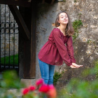 Jeune femme portant une blouse Mirabelle dans un jardin, patron de couture pdf à télécharger, tailles 34 au 56, 4 statures.