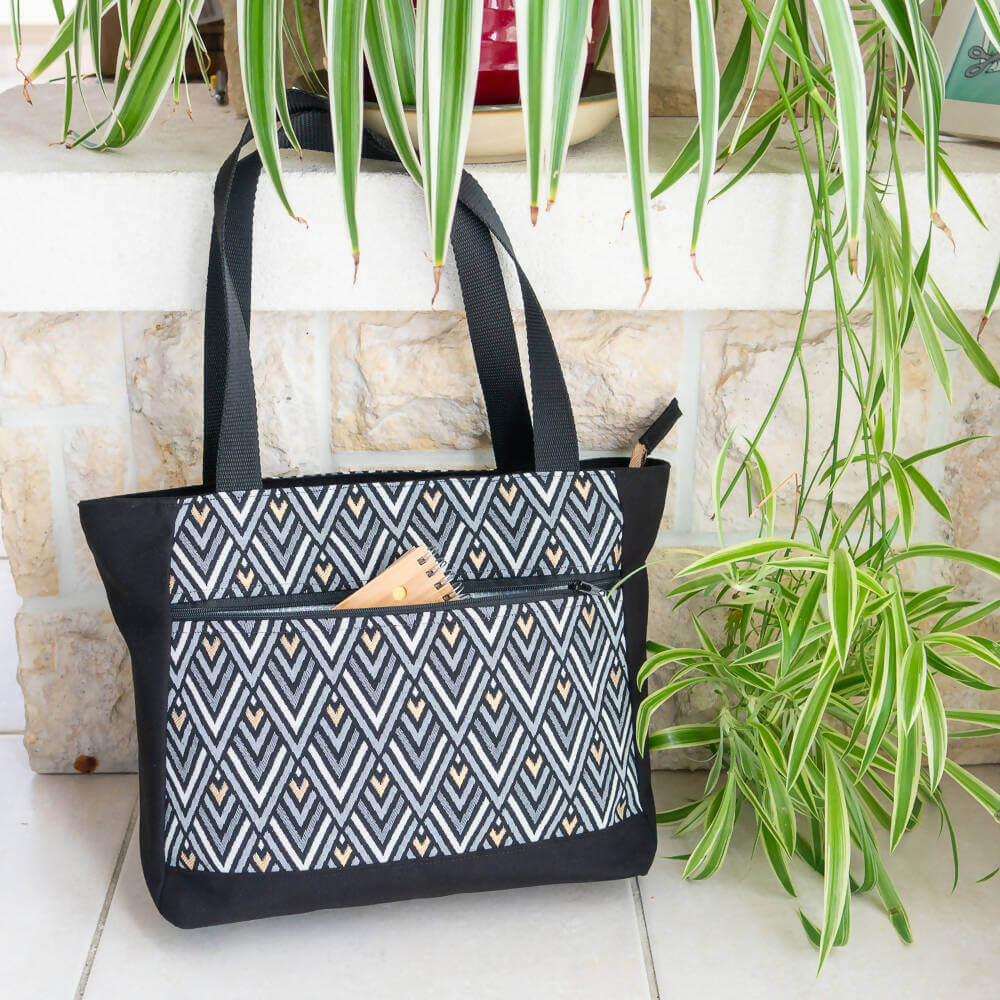 Sac cabas et sac à main, 4 tailles – Cumin avec motif géométrique, patron de couture pdf à télécharger, posé près de plantes vertes.