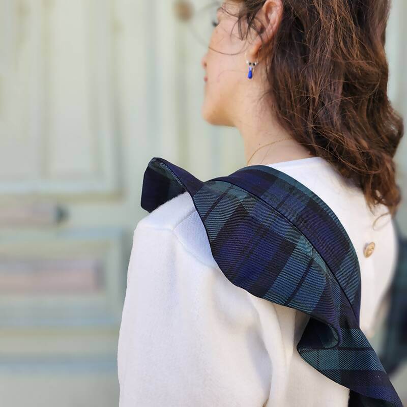 Jeune femme portant une salopette jupe plaidée, idéale pour un look décontracté et sophistiqué, associée au patron de couture pdf à télécharger.