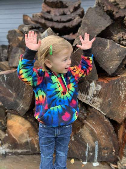 Enfant portant un sweat à capuche coloré devant des bûches, style unique de Sweat TITUS du 2 au 16 Ans, patron de couture pdf à télécharger.