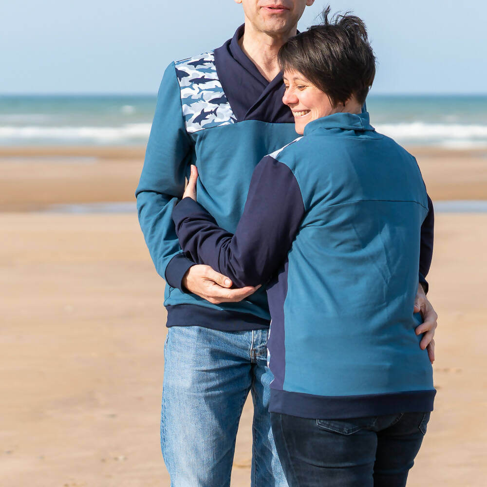 Couple portant le Sweat mixte, XS au 4XL, 2 statures – Anis, patron de couture pdf à télécharger, sur une plage ensoleillée.