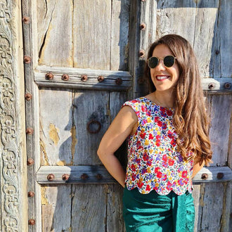 Femme portant le Top Fleury - T34 à 48, style estival coloré, patron de couture pdf à télécharger, sur fond de porte ancienne.