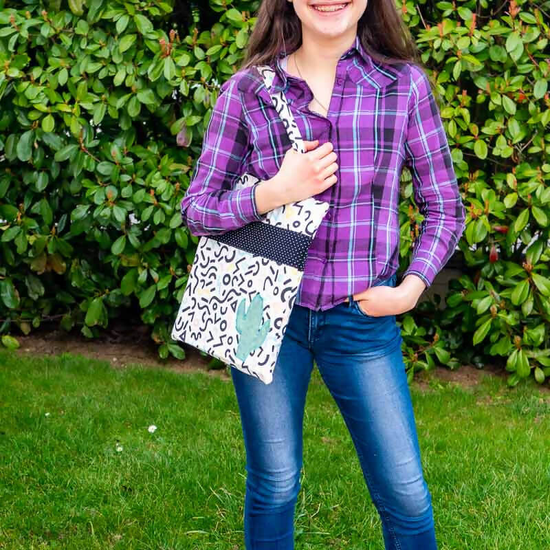 Femme portant un tote bag, avec couture anglaise, réalisé avec un patron de couture pdf à télécharger. Sac avec appliqués décoratifs.