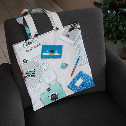 Tote bag, avec couture anglaise, sur un fauteuil gris, motif rétro avec appareil photo et cassette, patron de couture pdf à télécharger.